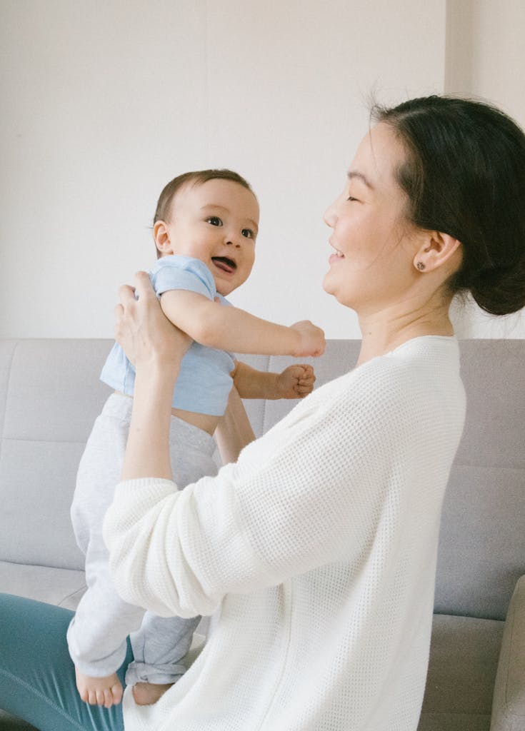 Woman in White Sweater Carrying Baby